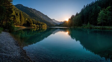A serene lake reflecting a vibrant sunrise over towering mountains and lush forests, showcasing a tranquil and peaceful scene.