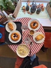 table with food, croissants, salmon soup, cappuccino