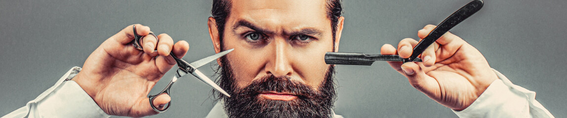 Brutal guy, scissors, straight razor, barber shop. Barber scissors and straight razor, barber shop, suit