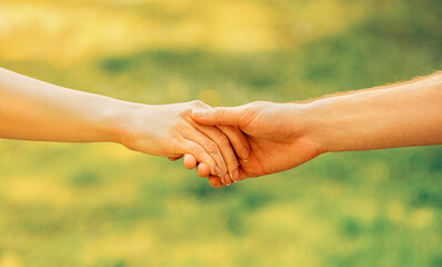 Give helping hand. Man and woman shaking hands against nature background