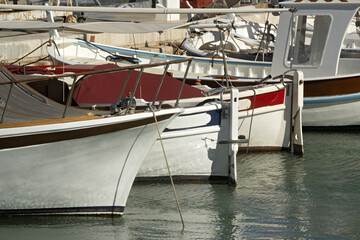 peaceful marina scene with a row of small boats docked side by side, their stern facing the viewer in Cassis, Provence, France