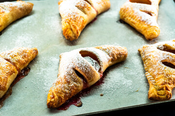 Puff pastry triangles with plum and cinnamon filling. Baked goods. Dessert. Food concept.