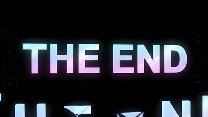 Cinematic finale screen featuring glowing pastel iridescent text spelling 'The End' against a dark background, symbolizing a conclusion or completion of a story