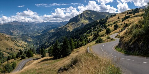 Mountain road winding through valley under a partly cloudy sky