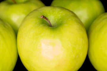 Juicy green apples isolated on black background, close-up.