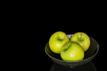 Juicy green apples isolated on black background, close-up.