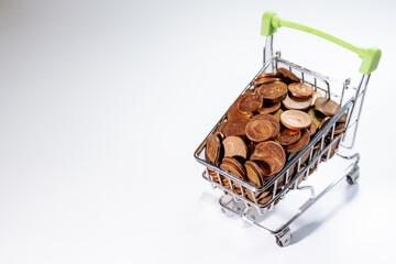 Mini shopping cart filled with euro cent coins, symbolizing savings, budgeting, expenses, commerce,...