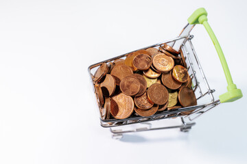Mini shopping cart filled with euro cent coins, symbolizing savings, budgeting, expenses, commerce,...