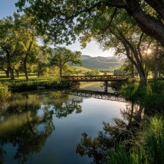 Fototapeta premium Serene sunrise over a tranquil pond, reflected in still waters, with a wooden bridge framed by lush trees and rolling hills in the background