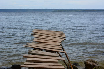 Fototapeta premium Weathered Wooden Pier Extending into a Calm Lake