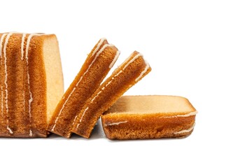 Close-up of golden loaf cake slices with icing drizzle, isolated on a white background.