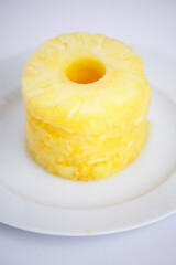 Stack of pineapple rings on a white plate