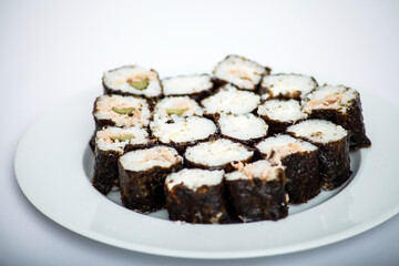 Sushi rolls arranged on a white plate, a delicious Japanese cuisine.