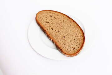 Slice of bread on a white plate against a bright white background.