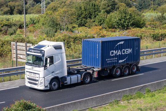 Volvo truck transporting cma cgm shipping container on highway
