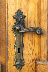 Antique Bronze Door Handle on Old Wooden Door