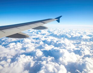 Obraz premium Wing of an airplane over a white cloudscape with a blue sky