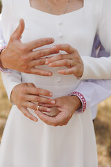 Close-up of bride and groom exchanging wedding rings outdoors. Hands gently touching, symbol of love, marriage, commitment, ceremony, and romantic union on special wedding day.