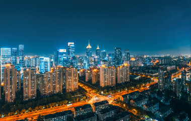 Fototapeta premium Dense modern urban cityscape with commercial buildings illuminated at night in Suzhou.
