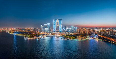 Obraz premium Panoramic view of the financial district skyline and modern architecture by the lake at dusk in Suzhou China.