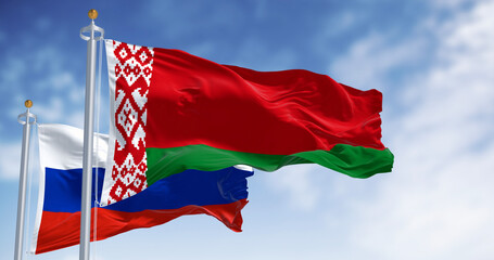 Belarus and Russia flags on flagpoles, 3D render of diplomacy