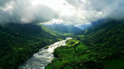 A breathtaking aerial shot of a majestic green mountain valley with a fast-flowing river. This is a perfect video for nature, travel, and environmental documentaries
