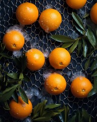 Bright orange tangerines with green foliage lie against a black background amidst snow. A creative vertical sales concept for a New Year's campaign