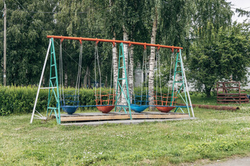 old swings on a playground in a park