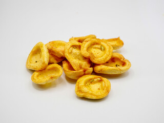 Close-up of golden crispy snake fruit chips (salak chips) on a white background. Perfect for healthy snack, exotic fruit, and tropical food concepts