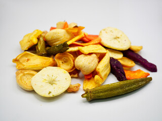 Dried fruit and vegetable chips mix arranged on a white background. Suitable for health food marketing, vegan lifestyle, and snack design