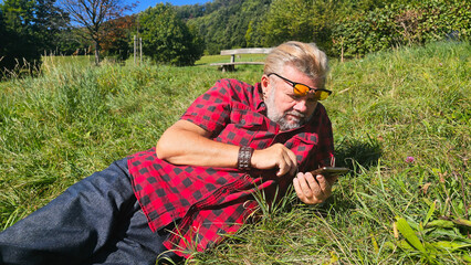 Mann mit Handy in Wiese