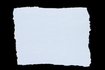 piece of white paper with torn edges against black background