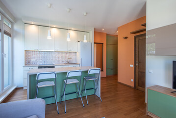 Modern Apartment Kitchen with Bar Stools and Warm Decorative Elements