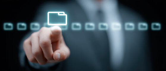 Focused individual uses digital document management system, selecting business folder and file