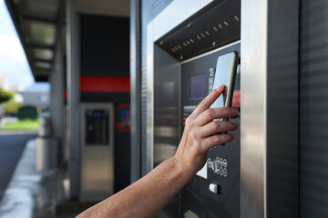 Mobile phone makes a contactless payment at a terminal, demonstrating modern digital technology, mobile banking, and safe cash-free payments. Suitable for fintech, innovation, and cashless living.
