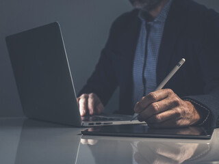 Strategic Creation: A Focused Professional Uses a Stylus and Tablet for Creative Digital Work