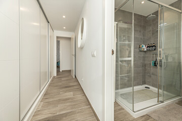 Bedroom with custom beveled mirrored wardrobe, built-in nightstands, and articulated reading lights.