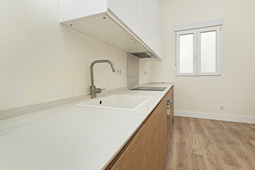 Contemporary open-plan kitchen design with white melamine cabinetry and walnut wood accents, perfect for large spaces