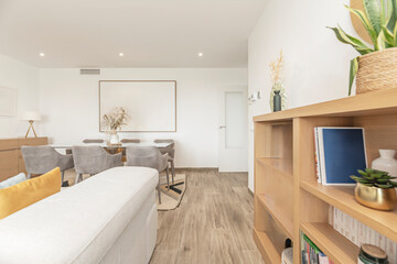 Living and dining room with pink velvet sofa, gold coffee table, and wooden dining room with pendant light