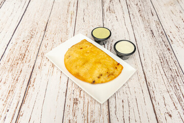 Shredded beef empanadas with Raisins and almonds, served with three sauces: guacamole, spicy salsa, and cilantro-lime salsa