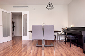 Minimalist design: a   table with tapered legs and Scandinavian-designed chairs in a bright space