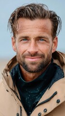Fototapeta premium Smiling young caucasian male outdoors in rain jacket