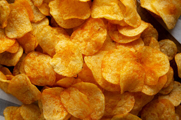 Homemade Flavored Cheese Potato Chips on a Wooden Board, top view.