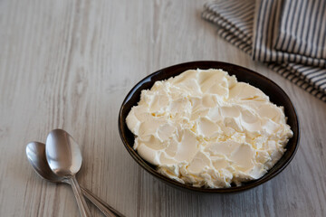 Organic White Mascarpone Cheese in a Bowl, side view. Copy space.
