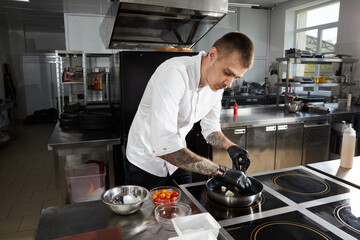 Chef cooking in the modern kitchen in hotel restaurant, preparing shrimp salad