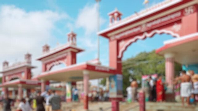 Bokeh view of Hindu people bathing in the Arabian Sea - ancient traditional ceremony before entering the temple in Rameshwaram, India. Blurred background footage.