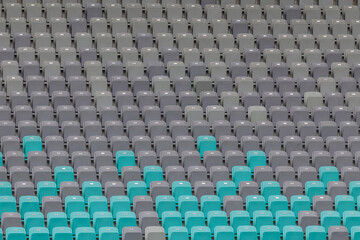 Naklejka premium Rows of seats in a football stadium showcase a mix of green and gray colors, creating a vibrant visual before the match.
