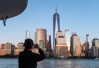 Tourist taking a photo of Manhattan from a boat. 