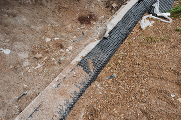 A compromised drainage system exposing geotextile on unstable soil raises concerns about...