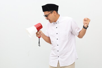 Fototapeta premium Emotional asian muslim man shouting at megaphone. Isolated on white background